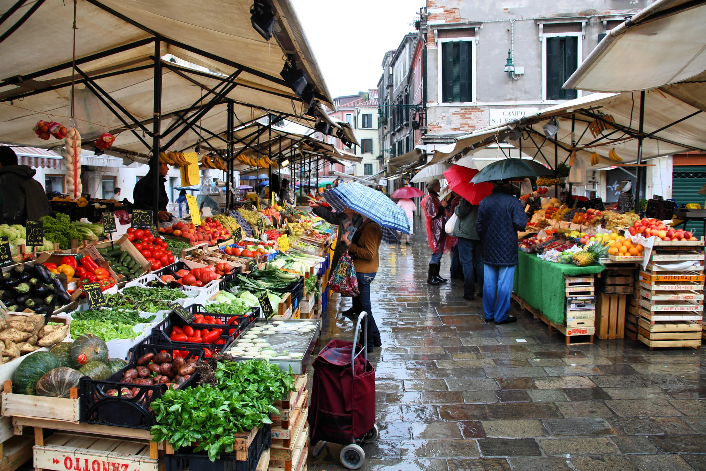 Fruttivendolo al mercato con clienti