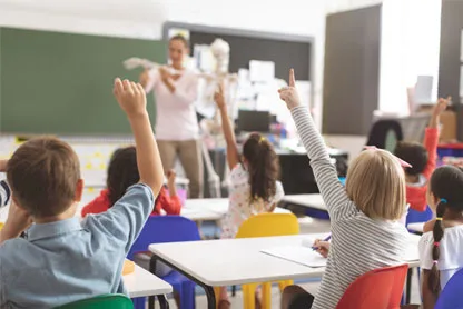 Bambini in classe con il braccio alzato